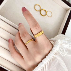 Detailed view of gold rings with Fu character and traditional floral patterns on velvet