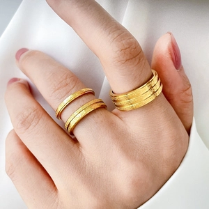 Detail of 18K gold-plated titanium steel rings featuring matte sandblasted textures