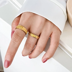 Macro shot of 18K gold plated titanium rings with engraved star patterns on models hand