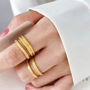 Close-up of matte 18K gold plated titanium steel rings with star engraving and sandblasted finish