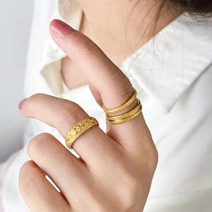 Detail of gold star engraved band and frosted sandblasted texture stacking rings