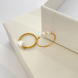 Detail of 18K gold-plated beaded rings featuring freshwater and baroque pearls
