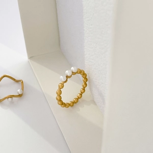 Detail view of gold beaded titanium steel ring featuring three vertical freshwater pearls