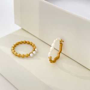 Detailed shot of 18K gold plated beaded ring with freshwater pearls and wavy hoop jewelry