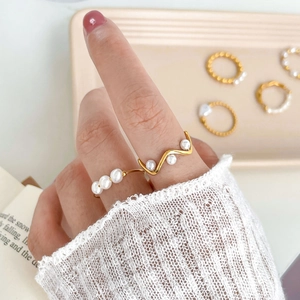 Detail view of layered freshwater pearl rings with 18K gold plated titanium steel bands