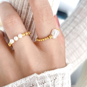 Detail of beaded rings with freshwater pearls and 18K gold plated beads on hand