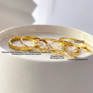 Macro detail of various geometric 18K gold faceted titanium and tungsten steel ring bands