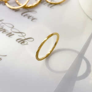 Macro shot of gold geometric faceted tungsten ring showing textured surface and long shadows