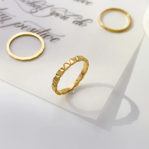 Macro detail showing geometric faceted texture on a gold tungsten steel triangle ring