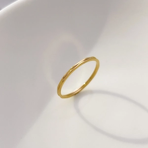 Macro view of slim golden tungsten ring featuring minimalist geometric faceted textures