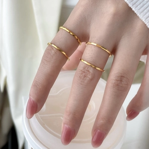 Set of four minimalist faceted gold tungsten rings for women on hand with warm aesthetic