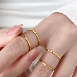 Close-up of gold geometric faceted rings with triangle cut and hammered texture details