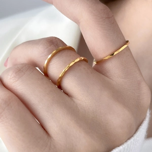 Detailed view of three stackable gold tungsten rings with geometric faceted surface