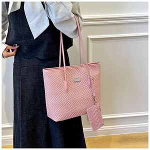 Detail of pink and white chevron woven tote bag with matching mini pouch and metal logo