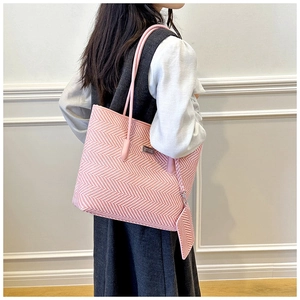 Pink and white herringbone weave tote bag with matching mini pouch shown on a model