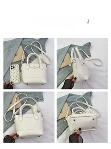 Detailed views showing the litchi pattern leather, handle, and bottom rivets of the white tote bag