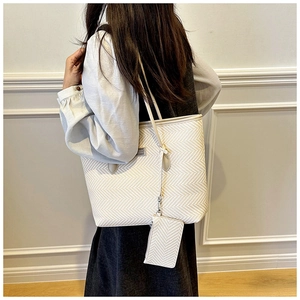 Detail of beige chevron woven tote bag with matching coin purse on shoulder