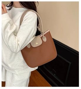 Detail of contrast stitching and flower logo on the caramel brown leather tote bag