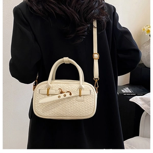 Détail du sac à main tressé crème avec rivets dorés et bandoulière réglable pratique