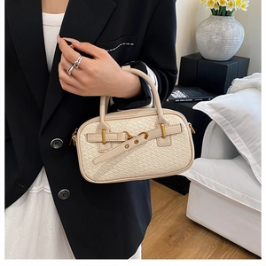 Détail d'un sac à main en cuir tressé crème avec ferrures dorées et boucle décorative