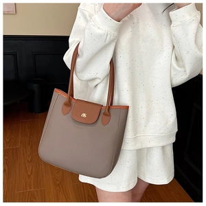 Detail view of the vintage greige and brown tote bag with metallic logo on textured leather