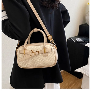 Détail du sac à main beige en texture tressée avec boucles dorées et poignées