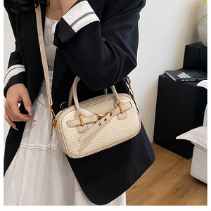 Détail du sac à main beige texture tissée avec dorures et bandoulière amovible
