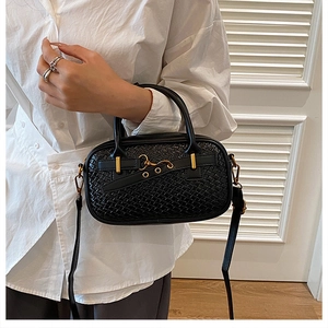 Détails d'un sac à main noir en cuir tressé avec des finitions en métal doré