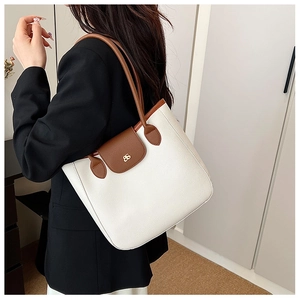 Detail of lychee pattern leather tote bag with brown straps and golden BS logo