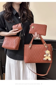 Detail of 4-piece brown embossed tote set with bear pendant and chain pattern texture