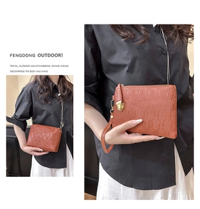 Brown embossed leather clutch with gold chain strap and detailed chain-link pattern texture