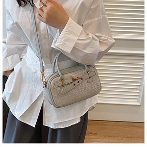 Détail de la texture tissée gris-bleu clair du sac à bandoulière avec finitions dorées