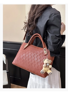 Brown embossed PU leather tote bag with chain pattern detail and bear charm accessory