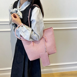 Pink and white woven tote bag with matching purse shown on shoulder for daily commute