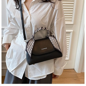 Detail of black leather handbag featuring woven texture and a stylish scarf wrapped handle