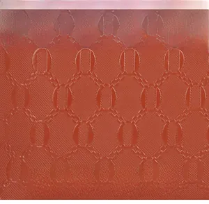 Macro detail of caramel orange leather featuring a refined embossed chain texture pattern