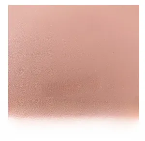 Macro detail of pink pebble leather texture with silver fashion lettering and stitching