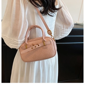 Détail du sac à main rose en cuir PU tressé avec boucle métallique dorée et poignée