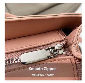 Macro detail of high-quality smooth metal zipper and leather texture on a pink handbag