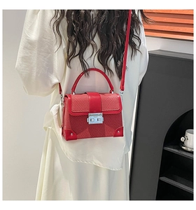 Detail of red snake-patterned PU leather bag with silver buckle and rivets