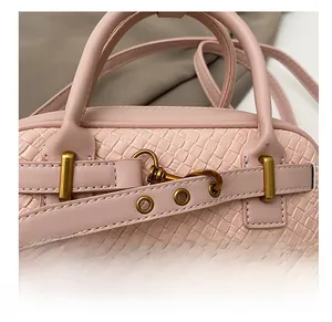 Détail du sac bowling rose clair à texture tressée et boucle décorative
