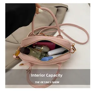 Détail de la capacité intérieure du sac bowling rose avec cosmétiques et fermetures dorées