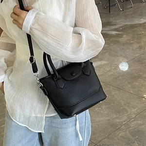 Minimalist black lychee leather bucket bag with top handles and silver hardware