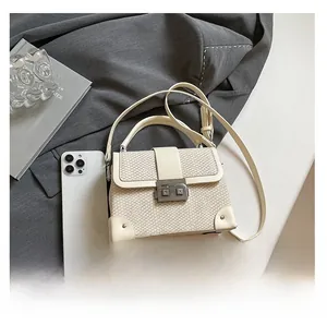 Detailed view of cream woven texture box bag with metal clasp and leather strap