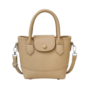 Warm camel bucket bag in lychee pattern leather with top handles and adjustable strap
