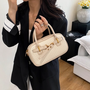 Sac à main élégant crème avec texture tissée vintage porté par un mannequin chic