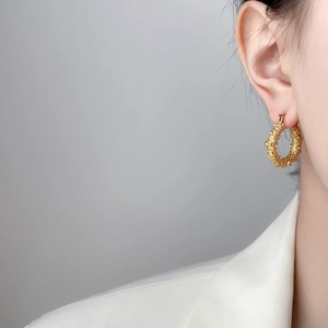Golden titanium steel C-hoop earrings with lava texture on professional model