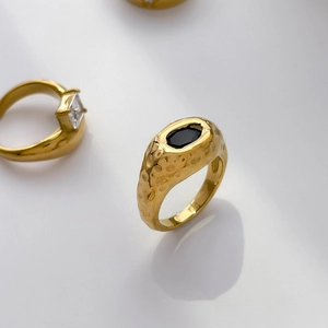 Détail d'une bague martelée plaquée or 18K avec pierre noire et accent en zircon carré