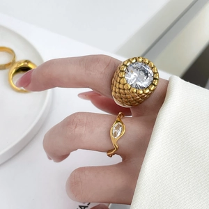 Gros plan sur bague large plaqué or 18 carats avec grand zircon et détails motif vagues
