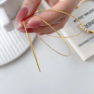 Three-piece set of thin gold bangles with twisted, polished, and faceted textures